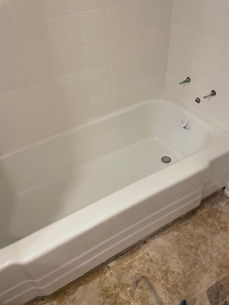 Bathroom tub refinishing results with bright white coating and tile surround