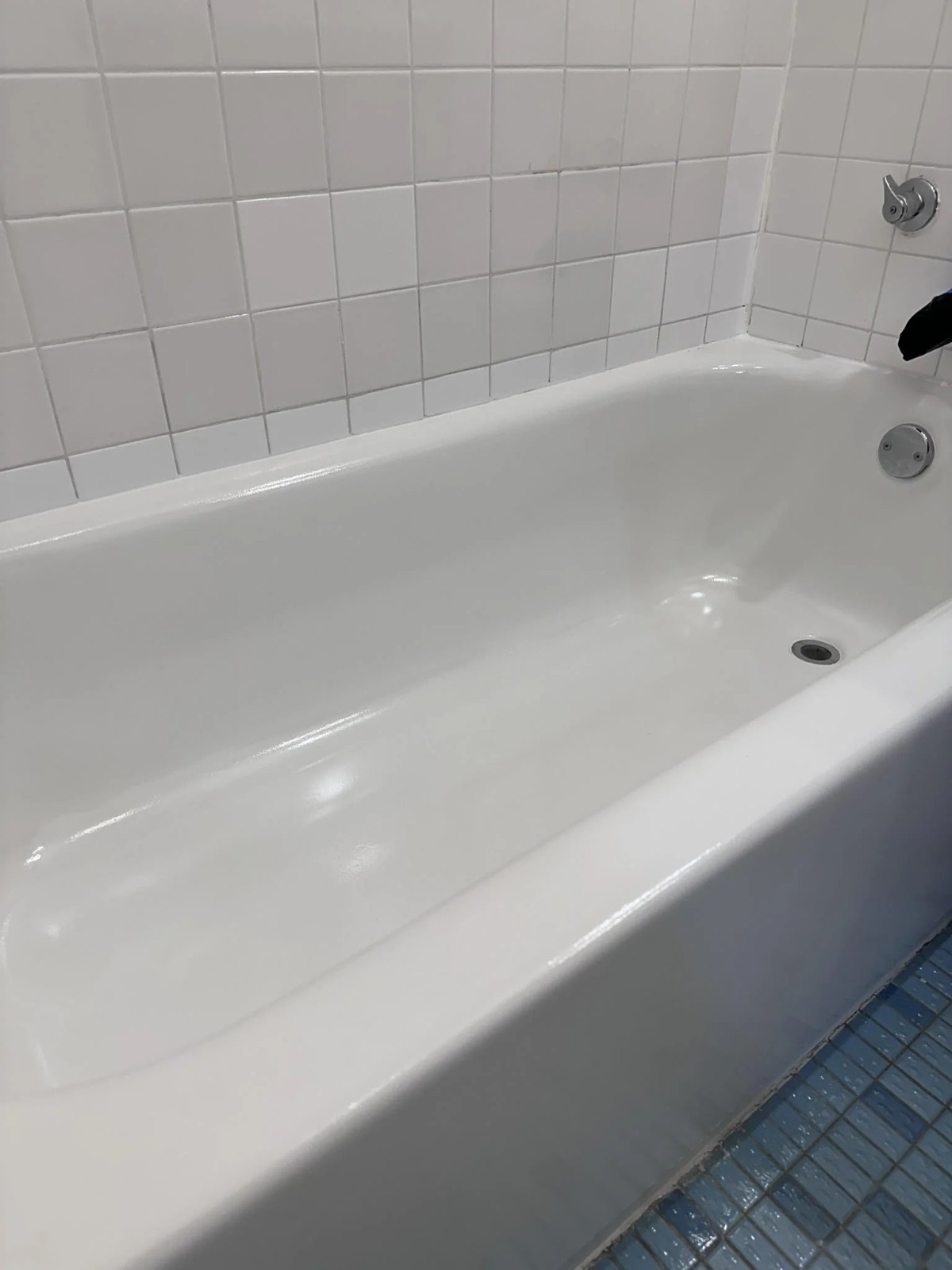 Bathtub refinishing results showing glossy white tub and tile surround